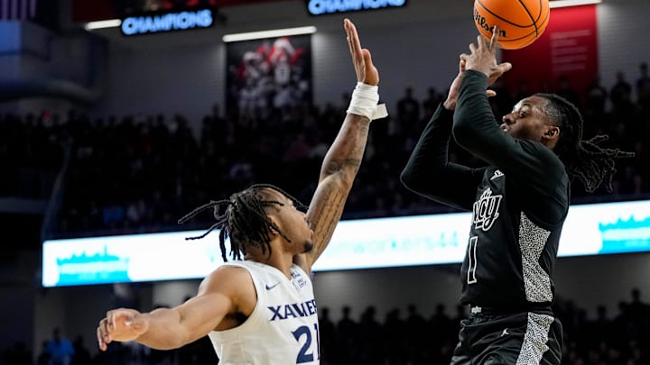 Cincinnati Bearcats guard Day Day Thomas (1) shoots over Xavier Musketeers guard Dante Maddox Jr. (21) in the second half of the 92nd Annual Crosstown Shootout NCAA basketball game between the Cincinnati Bearcats and the Xavier Musketeers at Fifth Third Arena on the UC campus in Cincinnati on Saturday, Dec. 14, 2024. The Bearcats won 68-65.
