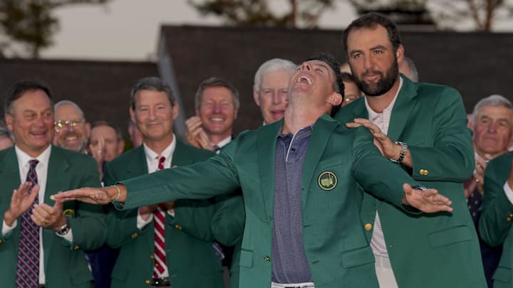 Scheffler places the green jacket on 2025 Masters champion Rory McIlroy.