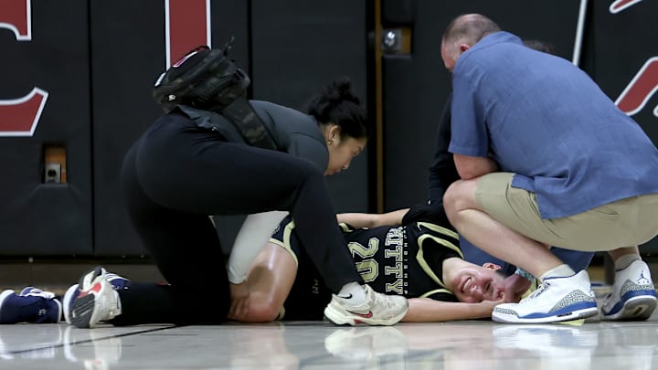 Mitty 6-2 junior McKenna Woliczko writhes in pain after a non-contact knee injury late in the first half of her team's 61-44 defeat to Ontario Christian in the 4th Sabrina Ionescu Showcase at Carondelet High School in Concord. 