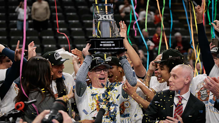 Mar 8, 2026; Kansas City, MO, USA; West Virginia Mountaineers coach Mark Kellogg is presented the championship trophy after the game against the TCU Horned Frogs at T-Mobile Center. Mandatory Credit: William Purnell-Imagn Images