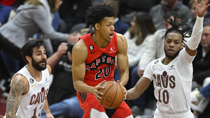 Feb 26, 2023; Cleveland, Ohio, USA; Toronto Raptors guard Jeff Dowtin Jr. (20) looks to pass between Cleveland Cavaliers guard Ricky Rubio (13) and guard Darius Garland (10) in the fourth quarter at Rocket Mortgage FieldHouse. Mandatory Credit: David Richard-Imagn Images