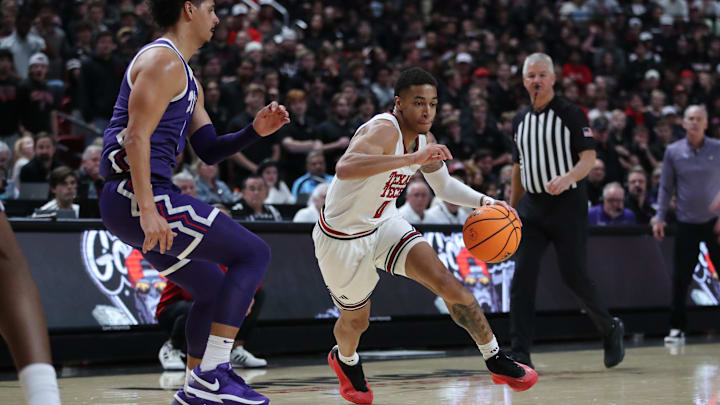 Jan 29, 2025; Lubbock, Texas, USA;  Texas Tech Red Raiders guard Chance McMillian (0) drives the ball against Texas Christian Horned Frogs guard Brendan Wenzel (0) in the second half at United Supermarkets Arena. Mandatory Credit: Michael C. Johnson-Imagn Images