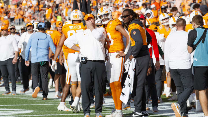 Jan 1, 2024; Orlando, FL, USA; Tennessee Volunteers head coach Josh Heupel, quarterback Nico Iamaleava (8) and quarterback Joe Milton III (7) talk against the Iowa Hawkeyes during the third quarter at Camping World Stadium. Mandatory Credit: Morgan Tencza-USA TODAY Sports