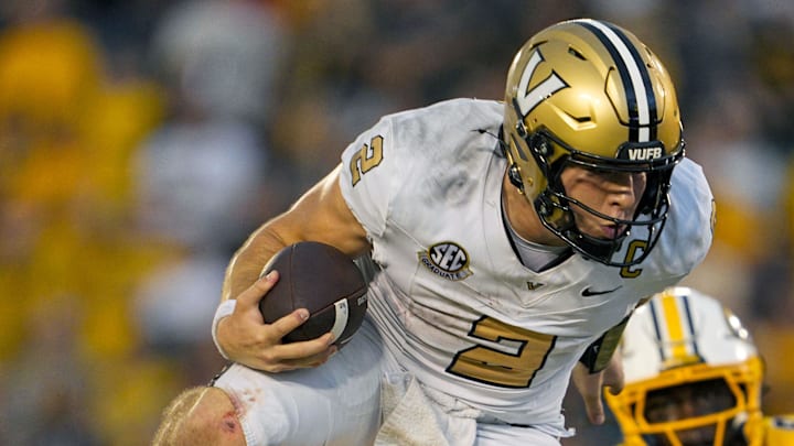 Sep 21, 2024; Columbia, Missouri, USA; Vanderbilt Commodores quarterback Diego Pavia (2) leaps over Missouri Tigers safety Marvin Burks Jr. (1) during overtime at Faurot Field at Memorial Stadium. Mandatory Credit: Jay Biggerstaff-Imagn Images