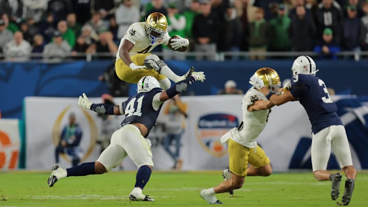 Notre Dame Fighting Irish running back Jeremiyah Love (4) leaps over Penn State Nittany Lions linebacker Kobe King (41) in the second half in the Orange Bowl at Hard Rock Stadium. Notre Dame Fighting Irish running back Jeremiyah Love (4) leaps over Penn State Nittany Lions linebacker Kobe King (41) in the second half in the Orange Bowl at Hard Rock Stadium.