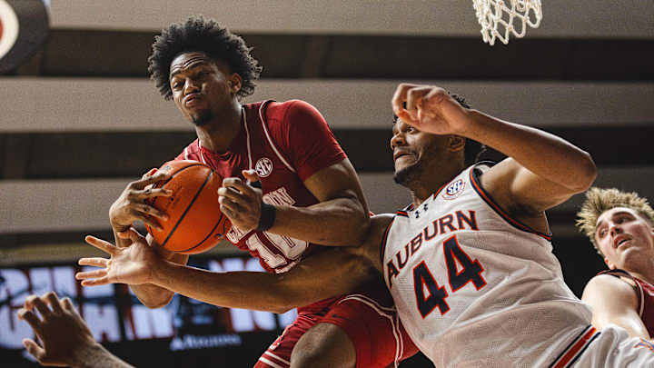 Feb 15, 2025; Tuscaloosa, Alabama, USA; Alabama Crimson Tide forward Mouhamed Dioubate (10) recovers a rebound against Auburn Tigers center Dylan Cardwell (44) during the first half at Coleman Coliseum. Mandatory Credit: Will McLelland-Imagn Images