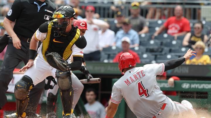 Jun 28, 2026; Pittsburgh, Pennsylvania, USA;  Cincinnati Reds right fielder Noelvi Marte (4) slides past Pittsburgh Pirates catcher Henry Davis (32) to score a run during the fifth inning at PNC Park. Mandatory Credit: Charles LeClaire-Imagn Images