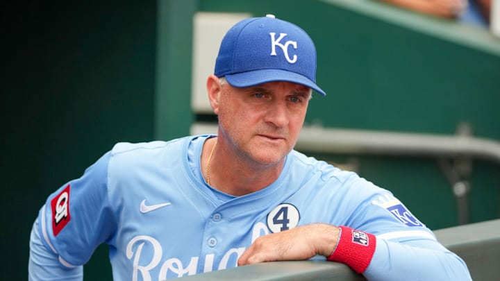 Jun 2, 2024; Kansas City, Missouri, USA; Kansas City Royals manager Matt Quatraro (33) watches from the dugout against the San Diego Padres showing the number four patch worn today in honor of Lou Gehrig Day in support of ALS prior to a game at Kauffman Stadium. Mandatory Credit: Denny Medley-Imagn Images