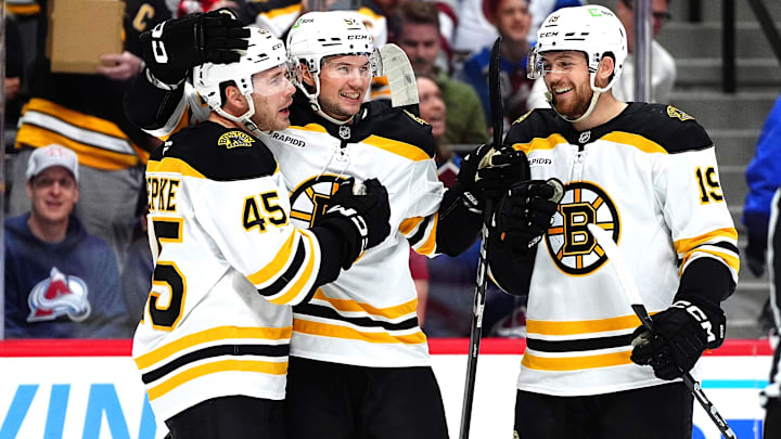 Oct 16, 2024; Denver, Colorado, USA; Boston Bruins left wing Cole Koepke (45) celebrates his goal with defenseman Andrew Peeke (52) and center John Beecher (19) in the first period against the Colorado Avalanche at Ball Arena. Mandatory Credit: Ron Chenoy-Imagn Images