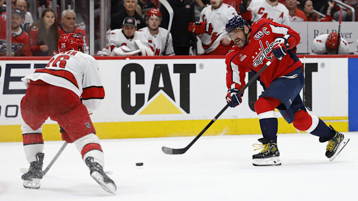 May 15, 2025; Washington, District of Columbia, USA; Washington Capitals left wing Alex Ovechkin (8) shoots the puck as Carolina Hurricanes defenseman Sean Walker (26) defends in the third period in game five of the second round of the 2025 Stanley Cup Playoffs at Capital One Arena. Mandatory Credit: Geoff Burke-Imagn Images