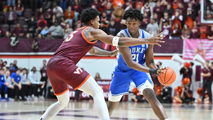 Jan 31, 2026; Blacksburg, Virginia, USA;  Duke Blue Devils center Patrick Ngongba (21) looks to pass the ball as Virginia Tech Hokies forward Amani Hansberry (13) defends during the first half at Cassell Coliseum. Mandatory Credit: Brian Bishop-Imagn Images