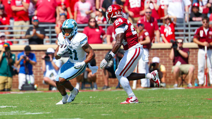 Sep 14, 2024; Norman, Oklahoma, USA;  Tulane Green Wave running back Makhi Hughes (21) runs with the ball as Oklahoma Sooners linebacker Samuel Omosigho (24) defends during the first half at Gaylord Family-Oklahoma Memorial Stadium. Mandatory Credit: Kevin Jairaj-Imagn Images