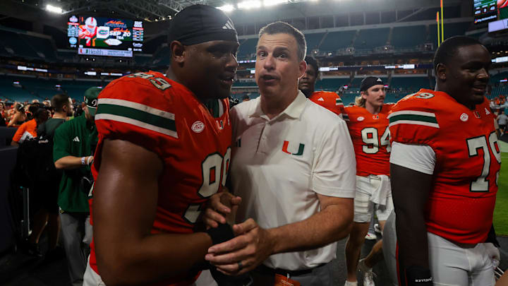 Sep 13, 2025; Miami Gardens, Florida, USA; Miami Hurricanes head coach Mario Cristobal celebrates with defensive lineman Ahmad Moten Sr. (99) after the game against the South Florida Bulls at Hard Rock Stadium. Mandatory Credit: Sam Navarro-Imagn Images Sep 13, 2025; Miami Gardens, Florida, USA; Miami Hurricanes head coach Mario Cristobal celebrates with defensive lineman Ahmad Moten Sr. (99) after the game against the South Florida Bulls at Hard Rock Stadium. Mandatory Credit: Sam Navarro-Imagn Images