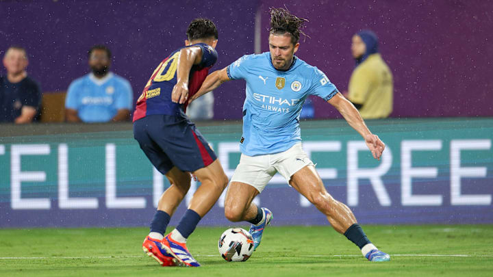 Jul 30, 2024; Orlando, FL, USA;  Manchester City midfielder Jack Grealish (10) controls the ball from Barcelona defender Hector Fort (20) in the first half during a Champions Tour friendly match at Camping World Stadium. Mandatory Credit: Nathan Ray Seebeck-Imagn Images