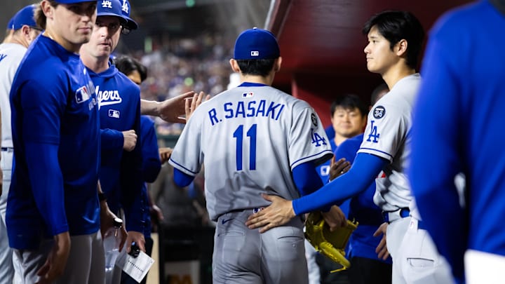 May 9, 2025; Phoenix, Arizona, USA; Los Angeles Dodgers pitcher Roki Sasaki (11) is greeted by Shohei Ohtani as he leaves the game in the fifth inning against the Arizona Diamondbacks at Chase Field. Mandatory Credit: Mark J. Rebilas-Imagn Images
