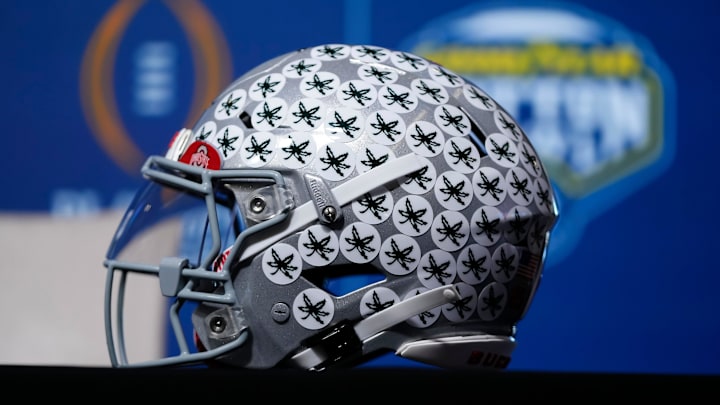 An Ohio State Buckeyes helmet sits in the desk in front of head coach Ryan Day as he talks to media during a Cotton Bowl press conference at AT&T Stadium in Arlington, Texas prior to their College Football Playoff quarterfinal matchup on Dec. 30, 2025. An Ohio State Buckeyes helmet sits in the desk in front of head coach Ryan Day as he talks to media during a Cotton Bowl press conference at AT&T Stadium in Arlington, Texas prior to their College Football Playoff quarterfinal matchup on Dec. 30, 2025.