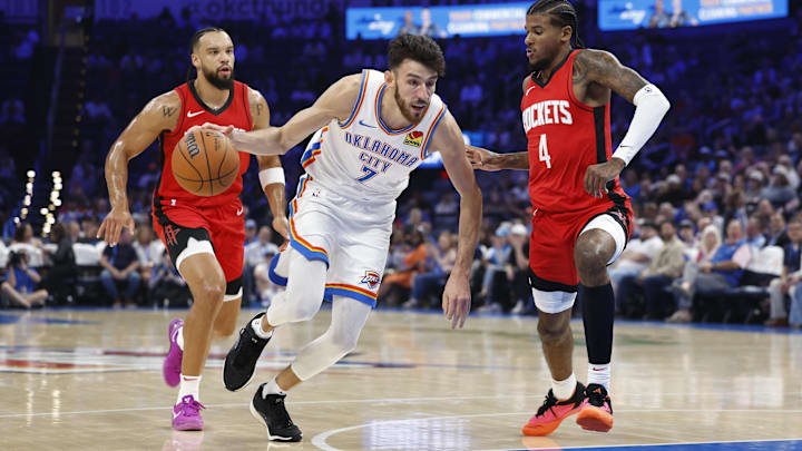 Oct 9, 2024; Oklahoma City, Oklahoma, USA; Oklahoma City Thunder forward Chet Holmgren (7) drives to the basket beside Houston Rockets guard Jalen Green (4) during the first quarter at Paycom Center. Mandatory Credit: Alonzo Adams-Imagn Images