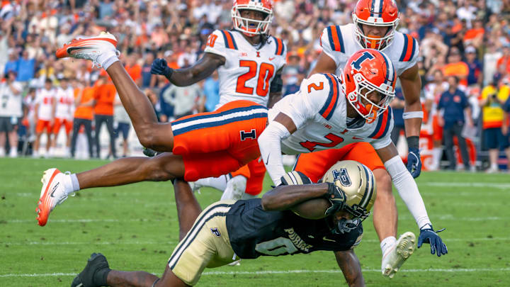 Oct 4, 2025; West Lafayette, Indiana, USA; Purdue Boilermakers wide receiver Nitro Tuggle dives short of the goal line against Illinois Fighting Illini defensive back Saboor Karriem (2) and defensive back Tyler Strain (20) during the second half at Ross-Ade Stadium. Mandatory Credit: Marc Lebryk-Imagn Images Oct 4, 2025; West Lafayette, Indiana, USA; Purdue Boilermakers wide receiver Nitro Tuggle dives short of the goal line against Illinois Fighting Illini defensive back Saboor Karriem (2) and defensive back Tyler Strain (20) during the second half at Ross-Ade Stadium. Mandatory Credit: Marc Lebryk-Imagn Images