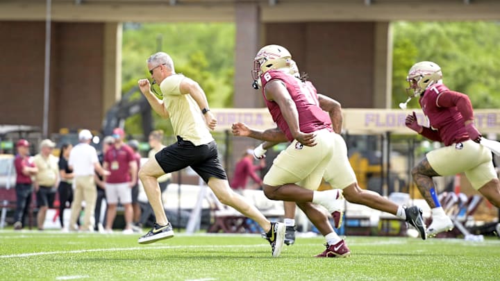 Apr 20, 2024; Tallahassee, Florida, USA; Florida State Seminoles head coach Mike Norvell races some of his players to the other end of the field during the Spring Showcase at Doak S. Campbell Stadium. Mandatory Credit: Melina Myers-USA TODAY Sports