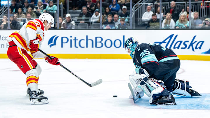 Feb 2, 2025; Seattle, Washington, USA;  Seattle Kraken goalie Joey Daccord (35) makes a save on a shot by Calgary Flames forward Yegor Sharangovich (17) during the third period at Climate Pledge Arena. Mandatory Credit: Stephen Brashear-Imagn Images