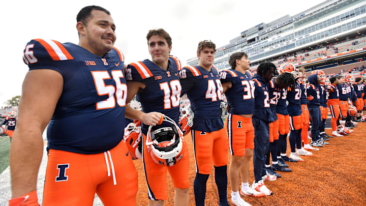 Nov 1, 2025; Champaign, Illinois, USA;  The Illinois Fighting Illini team stands as the band plays the school fight song after a win against the Rutgers Scarlet Knights at Memorial Stadium. Mandatory Credit: Ron Johnson-Imagn Images