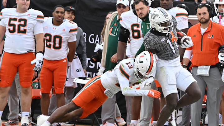 Nov 22, 2025; Blacksburg, Va.; Miami defensive back Bryce Fitzgerald (13) tackles Virginia Tech wide receiver Isaiah Spencer (11) during the fourth quarter at Lane Stadium.