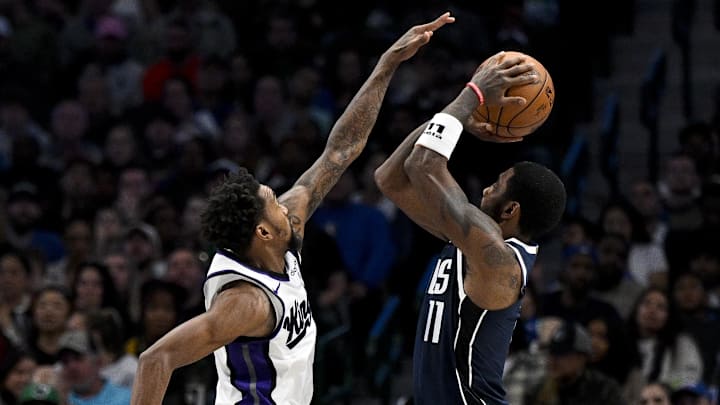 Nov 19, 2023; Dallas, Texas, USA; Dallas Mavericks guard Kyrie Irving (11) attempts a jump shot over Sacramento Kings guard Malik Monk (0) during the second half at the American Airlines Center. Mandatory Credit: Jerome Miron-Imagn Images