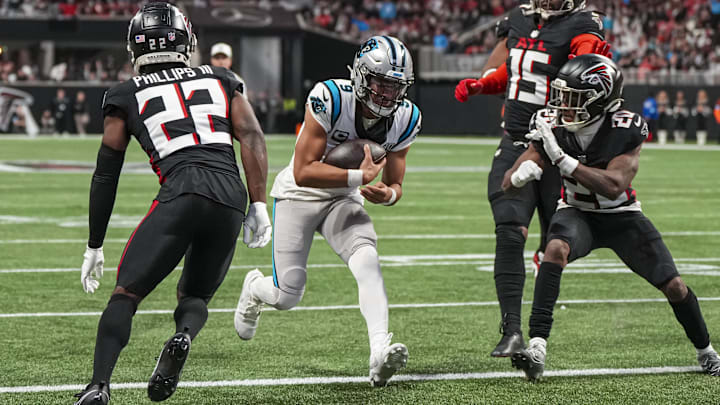 Jan 5, 2025; Atlanta, Georgia, USA; Carolina Panthers quarterback Bryce Young (9) runs for a touchdown between Atlanta Falcons cornerback Clark Phillips III (22) and cornerback Dee Alford (20) during the second half at Mercedes-Benz Stadium. Mandatory Credit: Dale Zanine-Imagn Images
