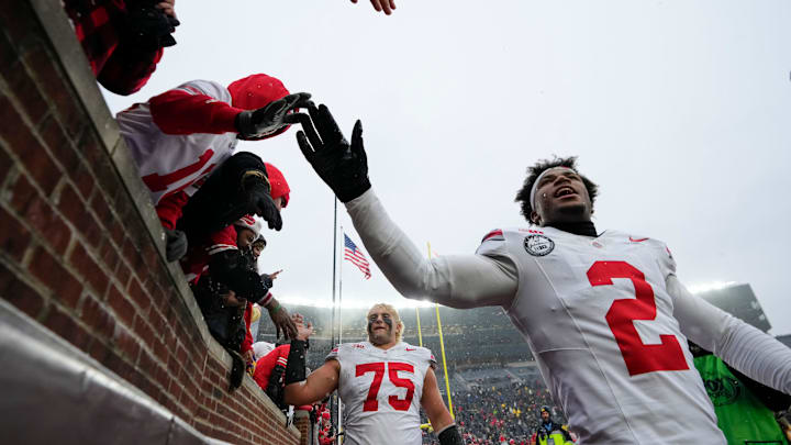 Ohio State Buckeyes defensive back Caleb Downs (2) high fives fans as he leaves the field following the NCAA football game against the Michigan Wolverines at Michigan Stadium in Ann Arbor, Mich. on Nov. 29, 2025. Ohio State won 27-9.
