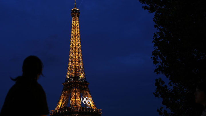 Jul 24, 2024; Paris, France; Tourists look at the Eiffel Tower before the Paris 2024 Olympic Summer Games. Mandatory Credit: Sarah Phipps-USA TODAY Sports