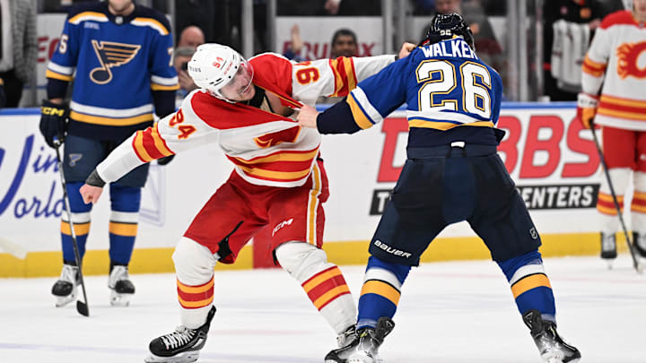 Jan 16, 2025; St. Louis, Missouri, USA; St. Louis Blues left wing Nathan Walker (26) fits Calgary Flames defenseman Brayden Pachal (94) in the third period at Enterprise Center. Mandatory Credit: Joe Puetz-Imagn Images