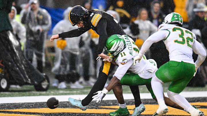 Nov 8, 2025; Iowa City, Iowa, USA; Iowa Hawkeyes punter Rhys Dakin (9) kicks the ball out of the end zone for a safety as Oregon Ducks wide receiver Jeremiah McClellan (11) and linebacker Nasir Wyatt (32) pursue during the first quarter at Kinnick Stadium. Mandatory Credit: Jeffrey Becker-Imagn Images