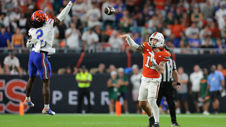 Sep 20, 2025; Miami Gardens, Florida, USA; Miami Hurricanes quarterback Carson Beck (11) passes the football as Florida Gators defensive back Lagonza Hayward (2) attempts a block during the fourth quarter at Hard Rock Stadium. Mandatory Credit: Sam Navarro-Imagn Images