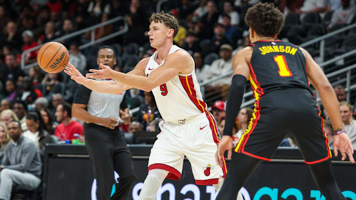 Dec 26, 2025; Atlanta, Georgia, USA; Miami Heat guard Pelle Larsson (9) makes a pass against Atlanta Hawks forward Jalen Johnson (1) during the first quarter at State Farm Arena. Mandatory Credit: Jordan Godfree-Imagn Images