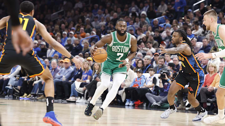 Jan 5, 2025; Oklahoma City, Oklahoma, USA; Boston Celtics guard Jaylen Brown (7) dribbles the ball between Oklahoma City Thunder guard Aaron Wiggins (21) and guard Cason Wallace (22) during the second quarter at Paycom Center. Mandatory Credit: Alonzo Adams-Imagn Images