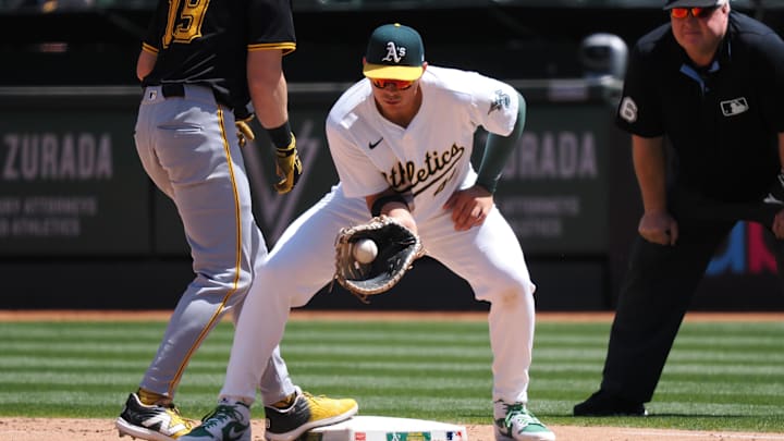 May 1, 2024; Oakland, California, USA; Oakland Athletics first baseman Ryan Noda (49) catches the ball as Pittsburgh Pirates second baseman Jared Triolo (19) returns safely to first base during the seventh inning at Oakland-Alameda County Coliseum. Mandatory Credit: Kelley L Cox-Imagn Images