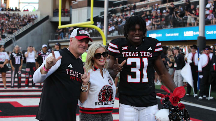 Nov 15, 2025; Lubbock, Texas, USA; Texas Tech Red Raiders head coach Joey McGuire and wife Debbie celebrate senior day with Texas Tech Red Raiders defensive end David Bailey (31) before the game against the Central Florida Knights at Jones AT&T Stadium. Mandatory Credit: Michael C. Johnson-Imagn Images Nov 15, 2025; Lubbock, Texas, USA; Texas Tech Red Raiders head coach Joey McGuire and wife Debbie celebrate senior day with Texas Tech Red Raiders defensive end David Bailey (31) before the game against the Central Florida Knights at Jones AT&T Stadium. Mandatory Credit: Michael C. Johnson-Imagn Images