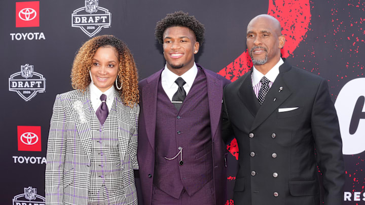 Ohio State Buckeyes defensive back Caleb Downs poses with his parents on the red carpet before the 2026 NFL Draft