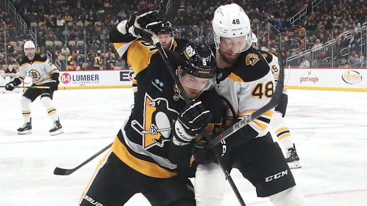 Ryan Shea protects the puck in his own zone against the Boston Bruins