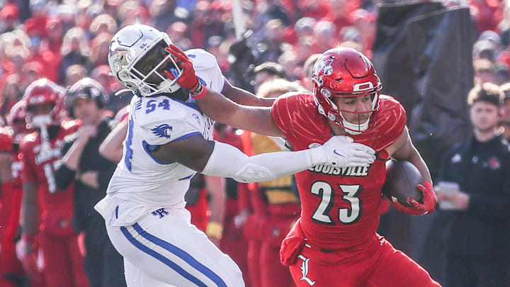 Kentucky Wildcats linebacker D'Eryk Jackson (54) tries to stop Louisville Cardinals running back Isaac Guerendo (23) in the first half of the 2023 Governor's Cup game in Louisville. Nov. 24, 2023