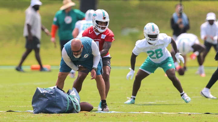 Miami Dolphins quarterback Tua Tagovailoa (1) works with running back De'Von Achane (28) during mandatory minicamp at Hard Rock Stadium.