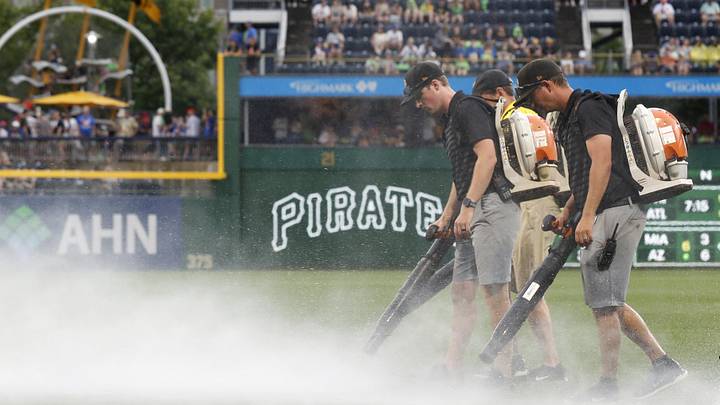 Jun 28, 2025; Pittsburgh, Pennsylvania, USA;  The PNC Park grounds crew attempts to blow rain off of the playing surface in order to resume the game against the New York Mets after a rain delay halted play in the second inning at PNC Park. Mandatory Credit: Charles LeClaire-Imagn Images