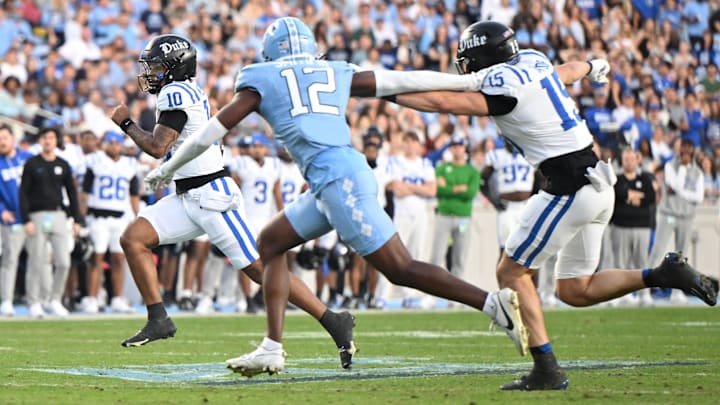 Nov 22, 2025; Chapel Hill, North Carolina, USA; Duke Blue Devils quarterback Darian Mensah (10) rushes for a first down during the first half at Kenan Stadium. Mandatory Credit: William Howard-Imagn Images