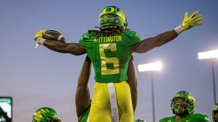 Oregon running back Noah Whittington is hoisted into the air after a touchdown.
