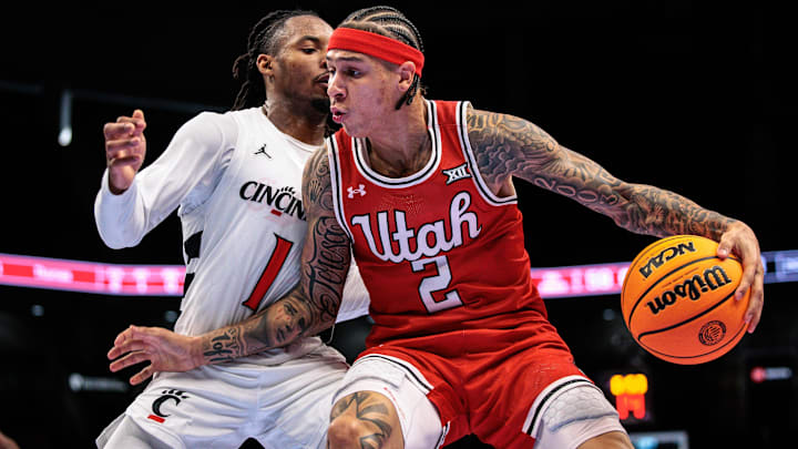 Mar 10, 2026; Kansas City, MO, USA; Utah Utes guard Terrence Brown (2) drives around Cincinnati Bearcats guard Day Day Thomas (1) during the second half at T-Mobile Center. Mandatory Credit: William Purnell-Imagn Images