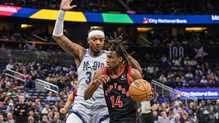 Mar 4, 2025; Orlando, Florida, USA; Toronto Raptors guard Ja'Kobe Walter (14) drives around Orlando Magic center Wendell Carter Jr. (34) during the second half at Kia Center. Mandatory Credit: Mike Watters-Imagn Images