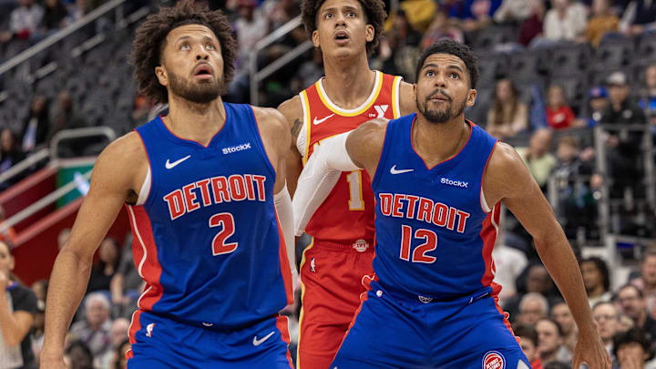Nov 8, 2024; Detroit, Michigan, USA; Detroit Pistons guard Cade Cunningham (2) and forward Tobias Harris (12) block out Atlanta Hawks forward Jalen Johnson (1) during the first half at Little Caesars Arena. Mandatory Credit: David Reginek-Imagn Images