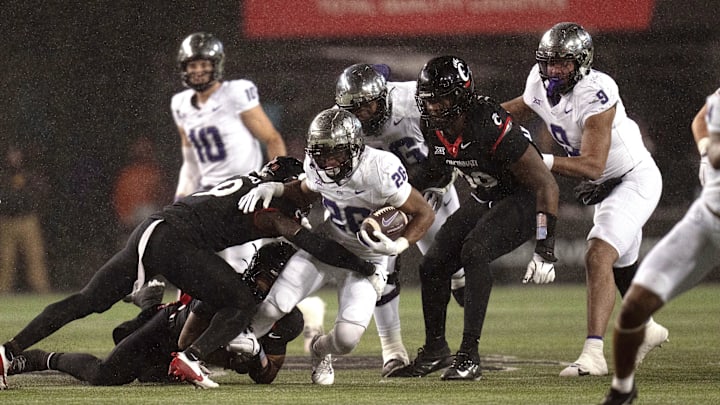 Nov 30, 2024; Cincinnati, Ohio, USA; TCU Horned Frogs running back Jeremy Payne (26) is tackled by Cincinnati Bearcats linebacker Jiquan Sanks (9) in the third quarter at Nippert Stadium. Mandatory Credit: Albert Cesare/USA TODAY Network via Imagn Images