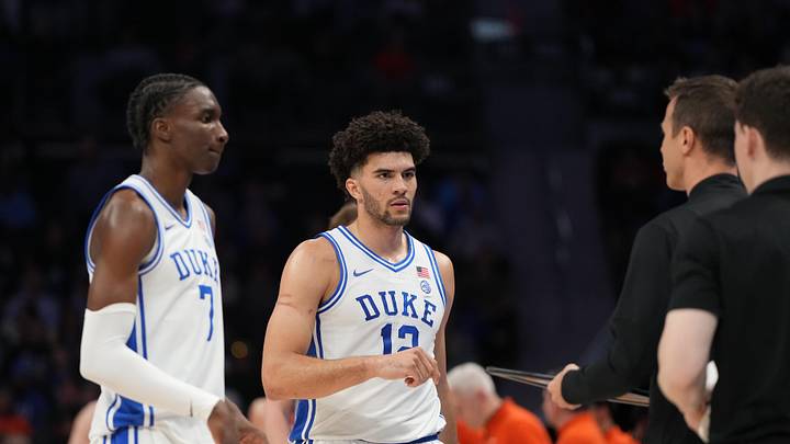 Mar 13, 2026; Charlotte, NC, USA; Duke Blue Devils guard Dame Sarr (7) and forward Cameron Boozer (12) with head coach Jon Scheyer in the first half at Spectrum Center.