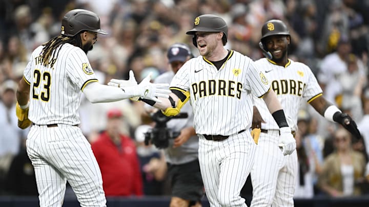 Jun 8, 2024; San Diego, California, USA; San Diego Padres first baseman Jake Cronenworth (9), center, is congratulated by San Diego Padres right fielder Fernando Tatis Jr. (23), left, as Jurickson Profar (10) looks on after hitting a three-run home run during the fourth inning against the Arizona Diamondbacks at Petco Park. Mandatory Credit: Denis Poroy-Imagn Images at Petco Park. 